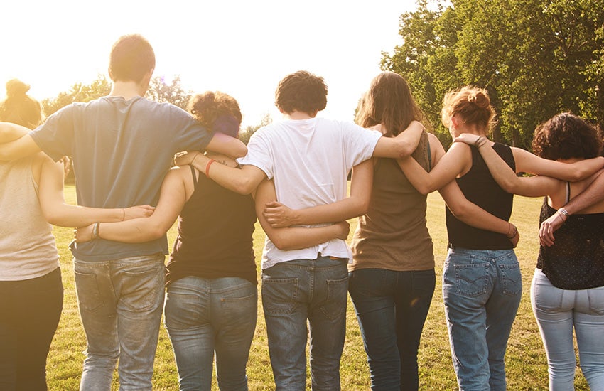 A group of people with their arms around each other