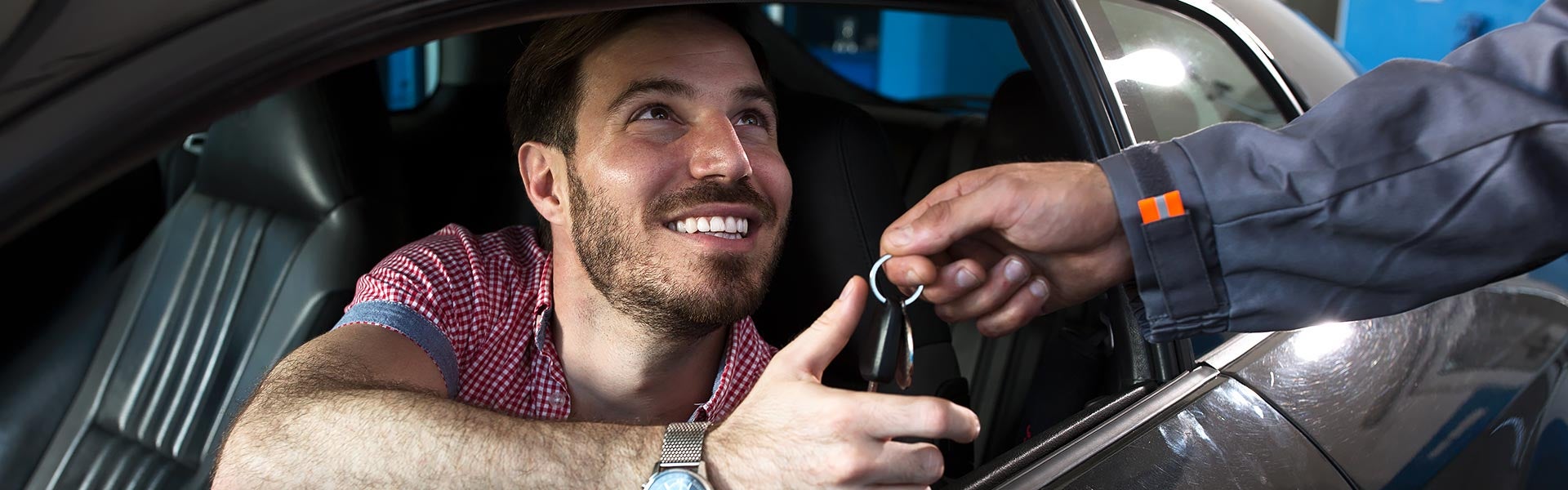 A man in a car being handed keys
